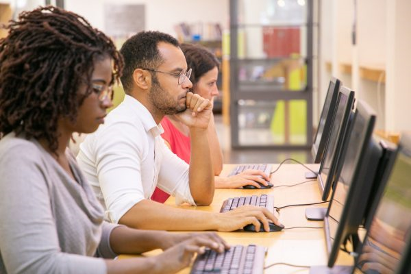 ENEM digital ou impresso: candidatos realizando uma prova digital em uma escola, com cada uma utilizando um computador